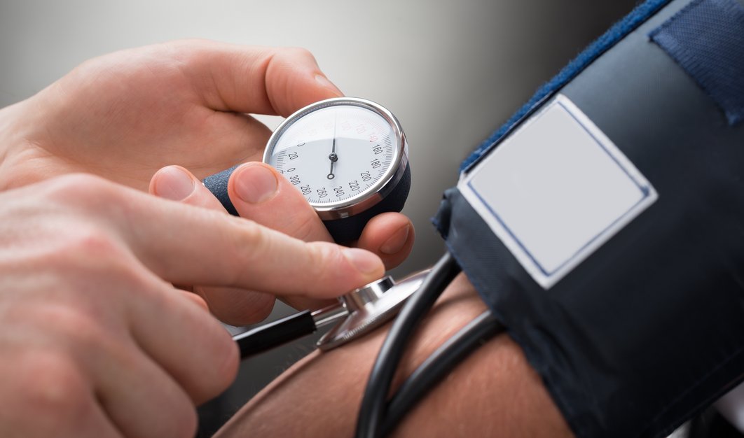 Blutdruckmessgerät an einem Arm, Hände halten Geräte