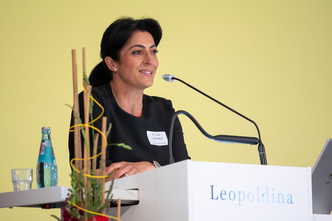 Dr. Lilit Flöther steht hinter einem Redepult und spricht in ein Mikrofon. Auf dem Pult steht der Schriftzug "Leopoldina".