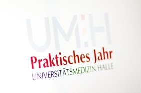 Symbolbild: Schriftzug "Praktisches Jahr" umrahmt mit dem Logo und der Wortmarke der Universitätsmedizin Halle.